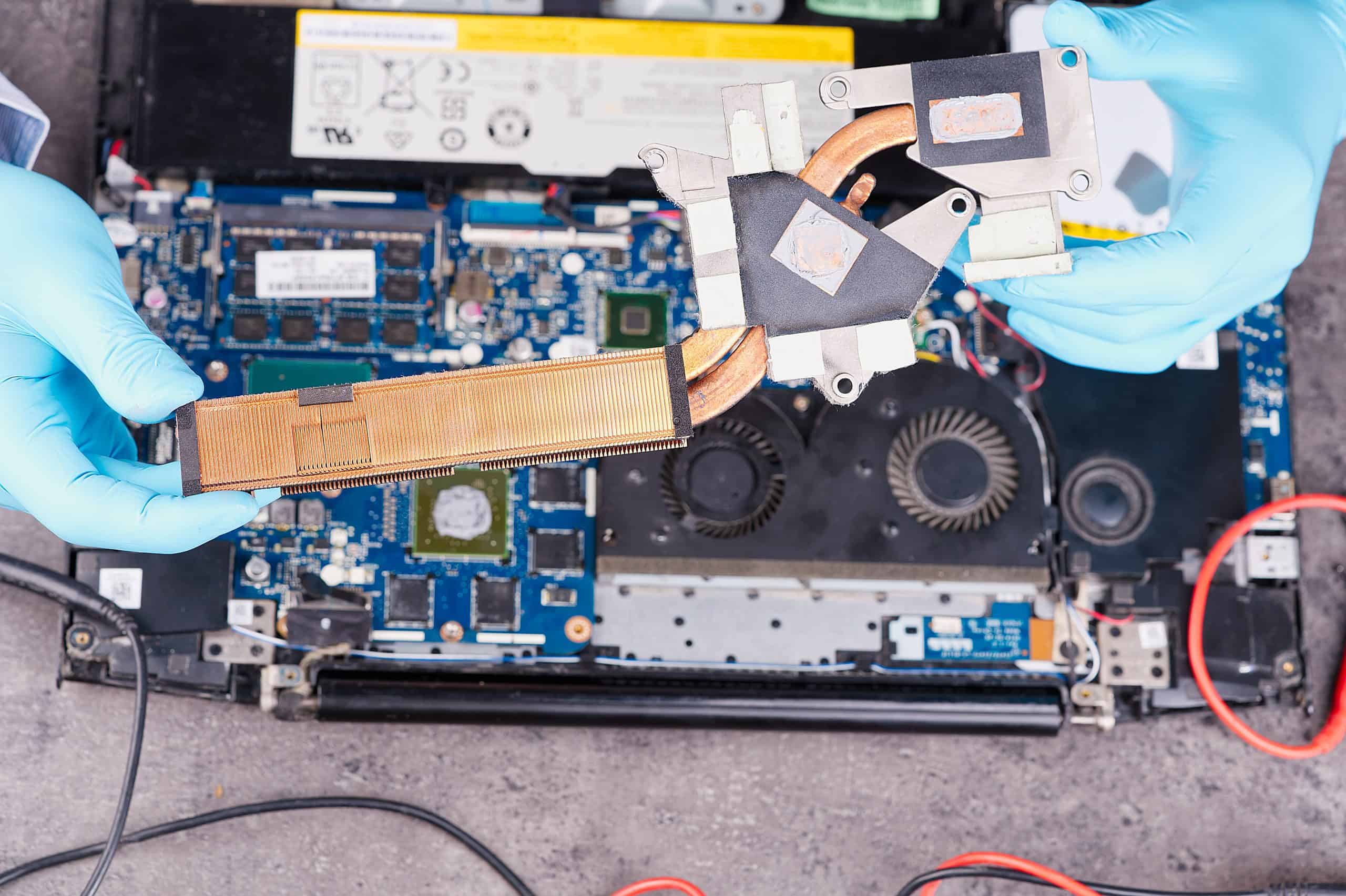 Hands fixing motherboard of pc or laptop notebook close up in service. Laptop repair service.
